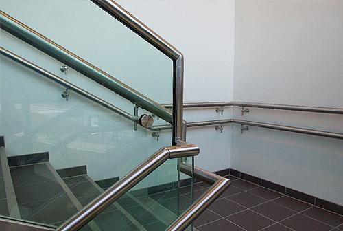 Una escalera con barandilla de acero inoxidable y barandilla de cristal.