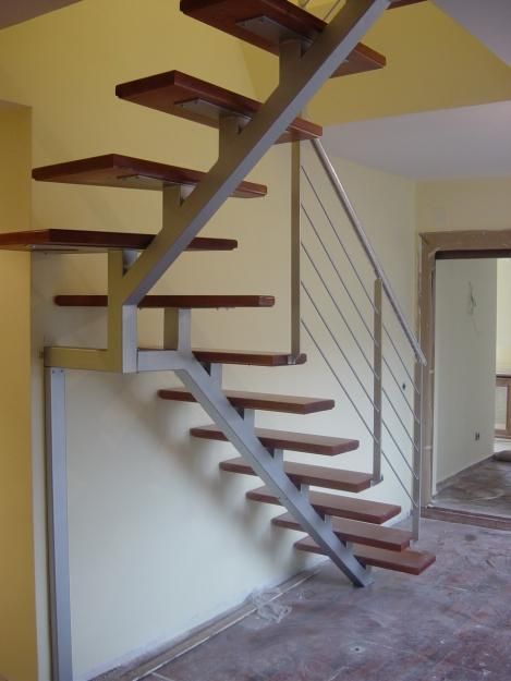 Una escalera con escalones de madera y barandilla de metal