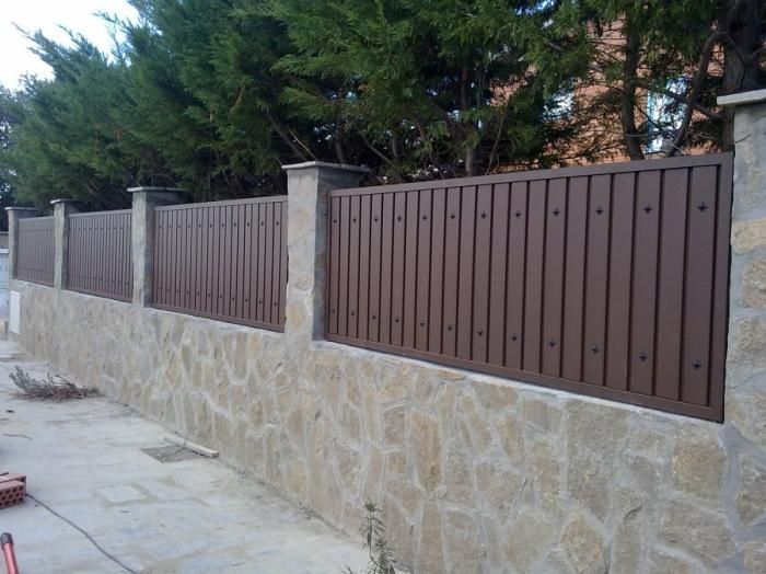 Un muro de piedra con una valla de madera que lo rodea.