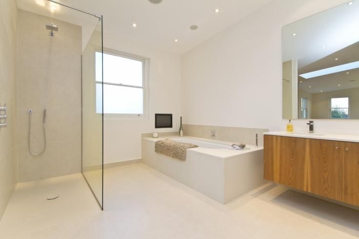 Un baño con bañera y ducha a ras de suelo.