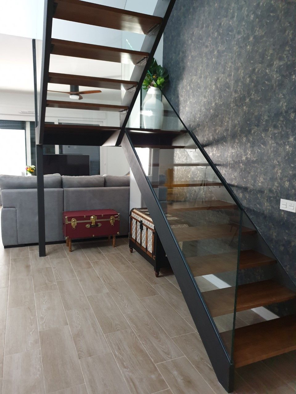 Una sala de estar con una escalera y un sofá.