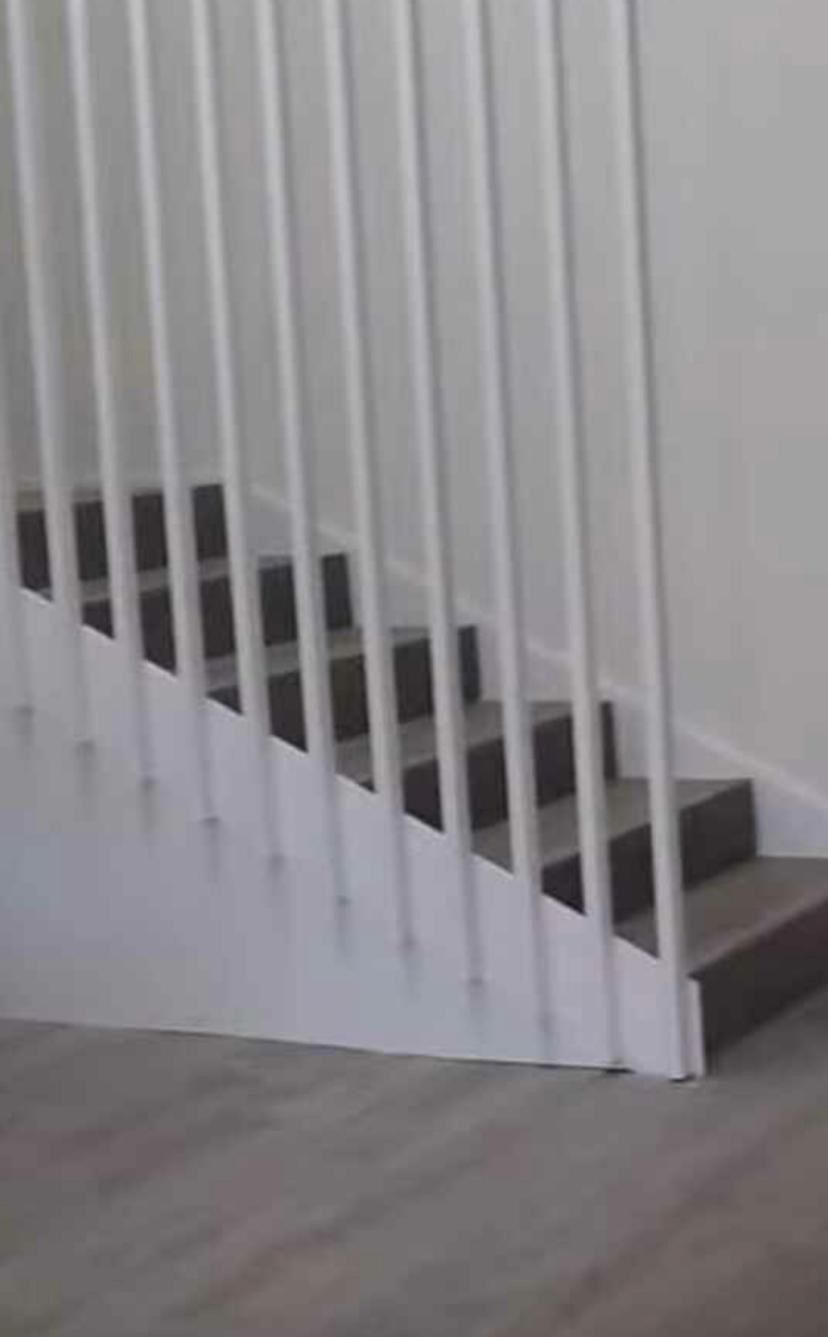 Un primer plano de una escalera con barandilla blanca.