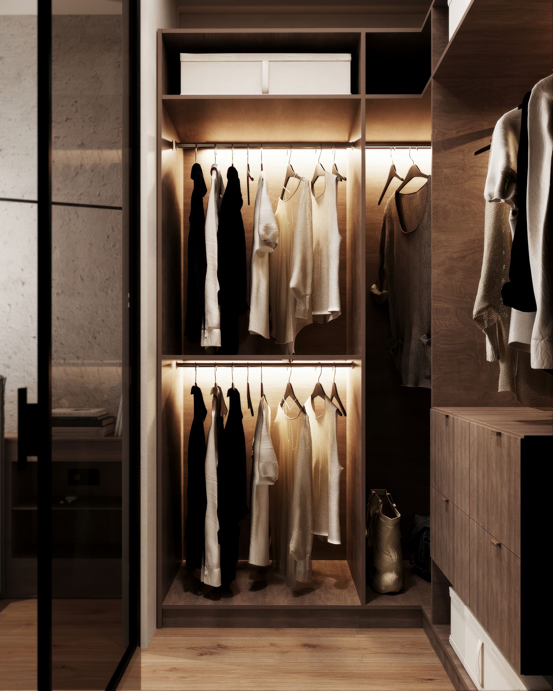 Dressing avec vêtements suspendus en noir et blanc, étagères en bois et éclairage chaleureux.