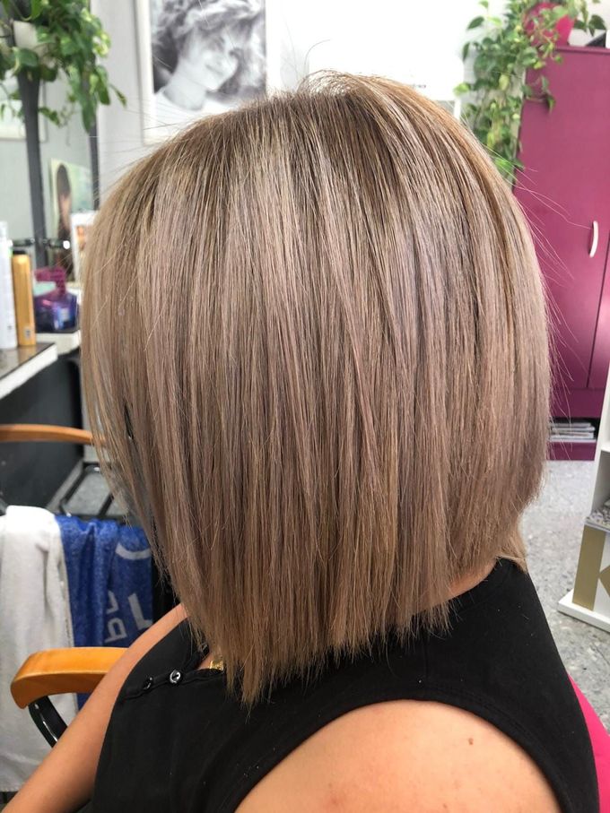 Una mujer con cabello rubio corto está sentada en una silla.