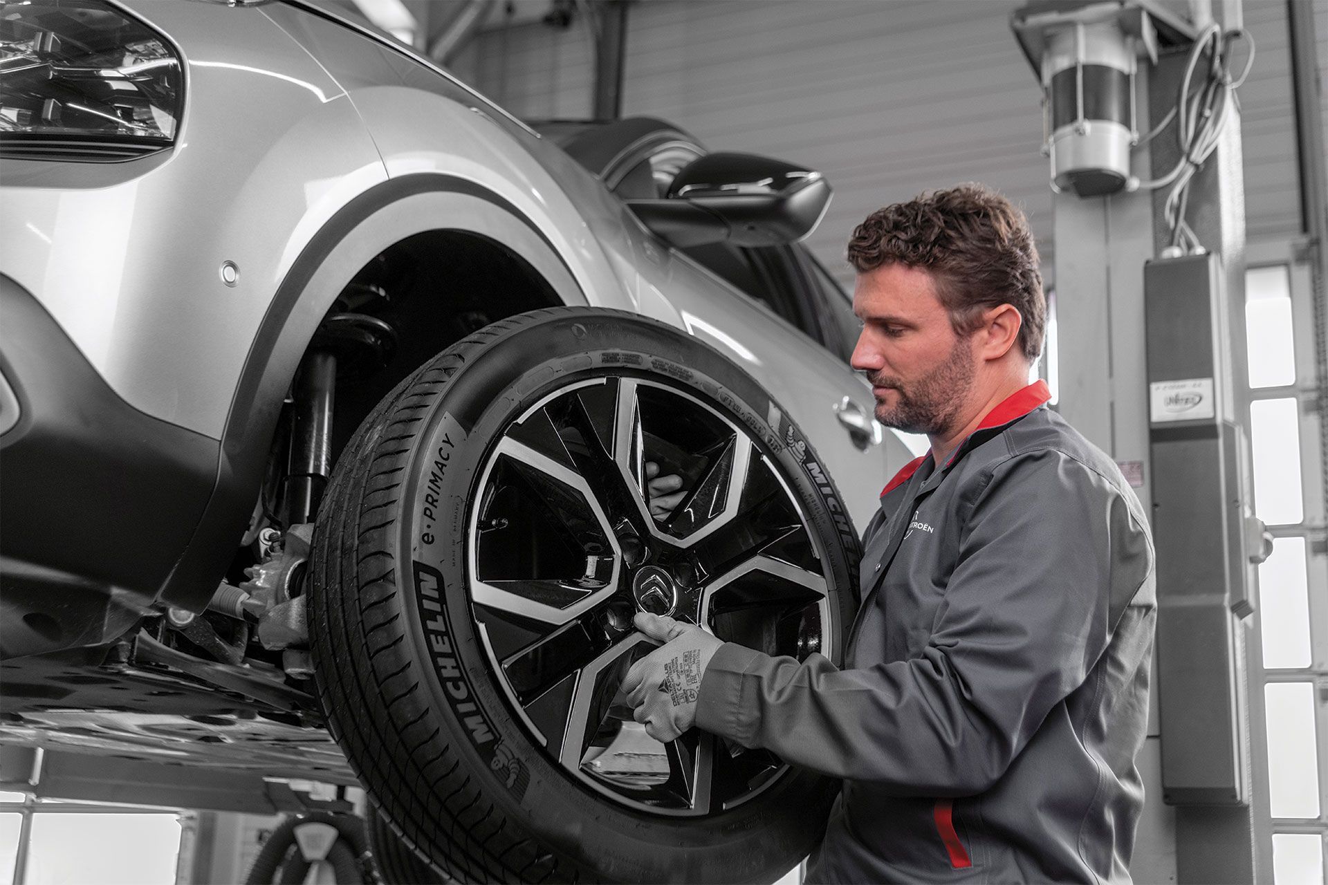 Un mécanicien change un pneu de voiture dans un atelier de réparation.