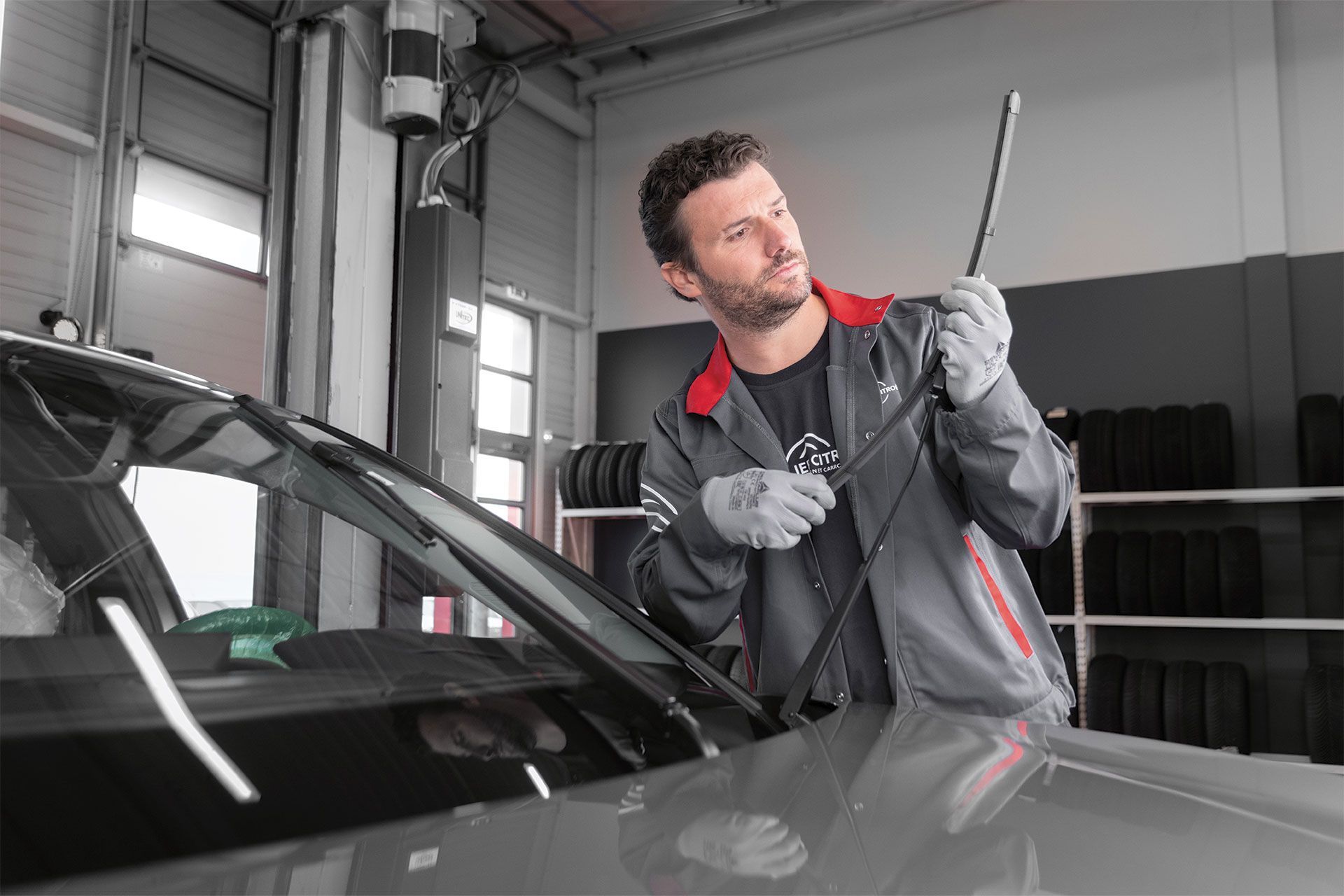 Un mécanicien remplace un essuie-glace dans un garage.