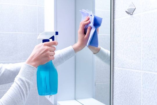 Reinigung eines Spiegels in einem Badezimmer