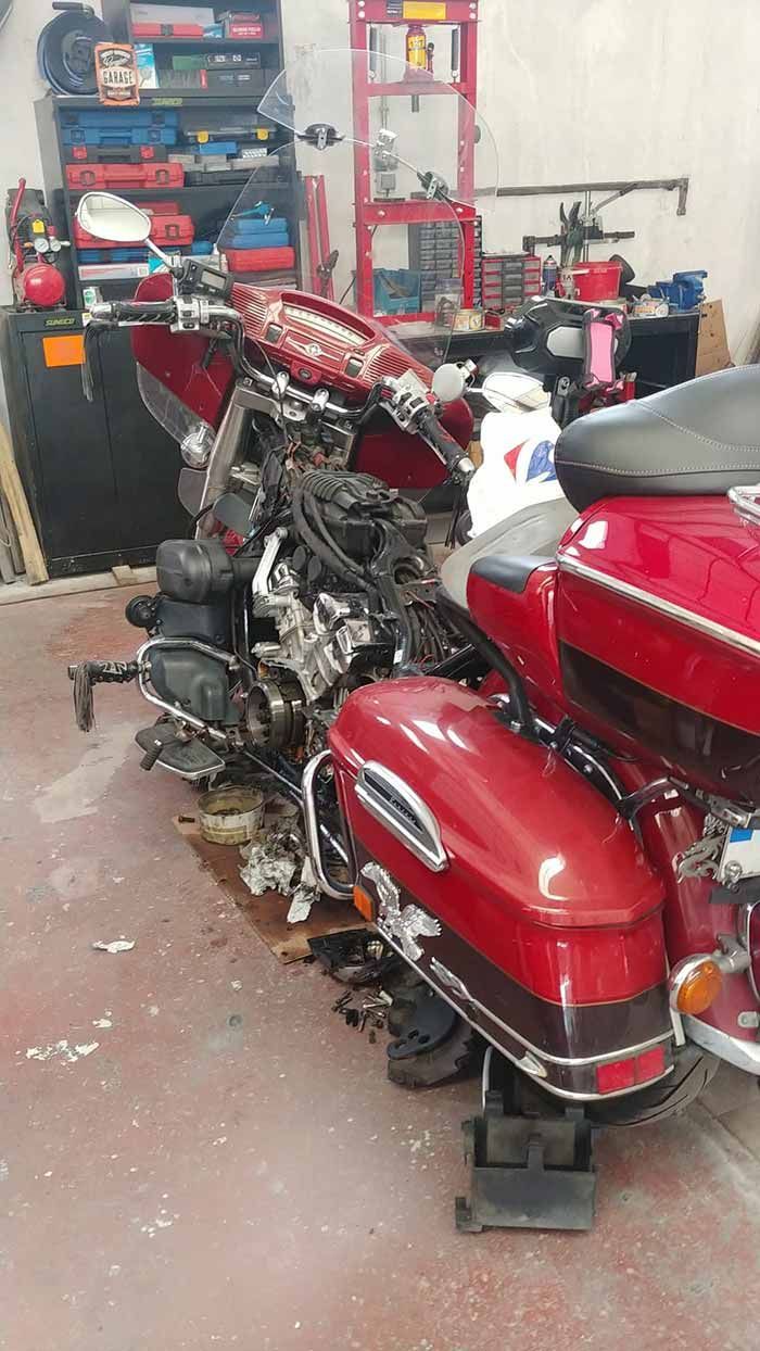 Una motocicleta roja está sentada en un elevador en un garaje.