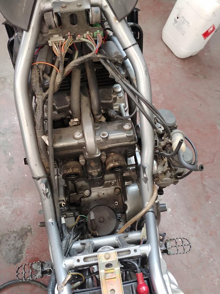 El motor de una motocicleta está apoyado en el suelo.