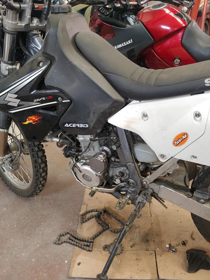 Una motocicleta está parada sobre una caja de cartón en un garaje.