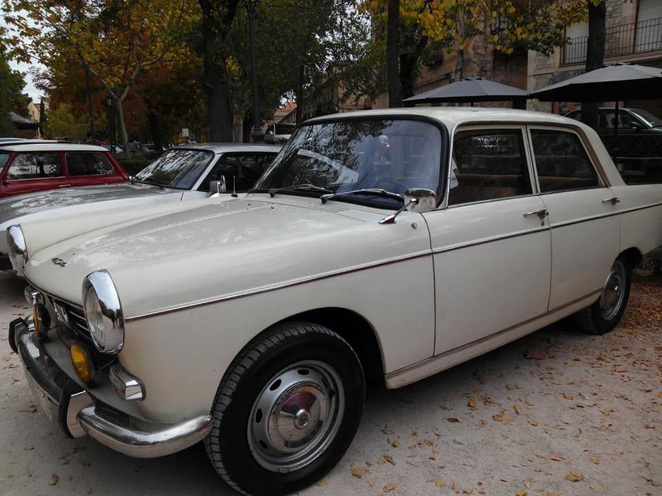 Un coche blanco está aparcado junto a otro coche en un estacionamiento.
