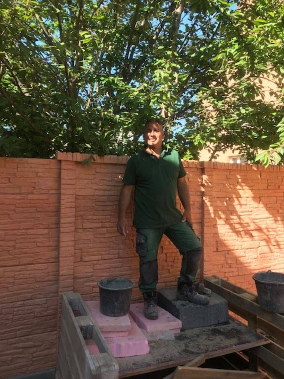 Mitarbeiter von ÖKo Gartenbau vor Natursteinmauer