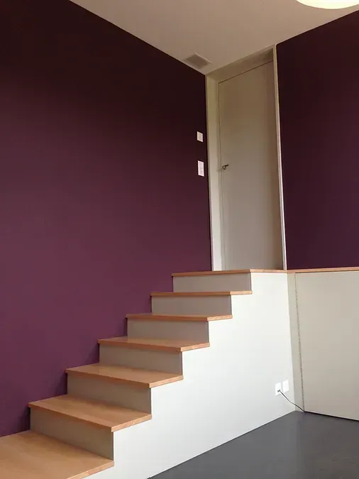 Eine Treppe in einem Raum mit violetten Wänden