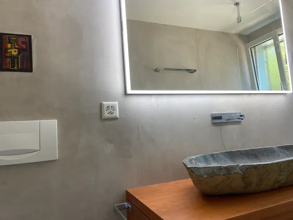 Ein Badezimmer mit Waschbecken und großem Spiegel