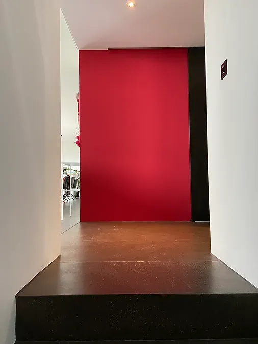 Ein Flur mit einer roten Wand und Treppe