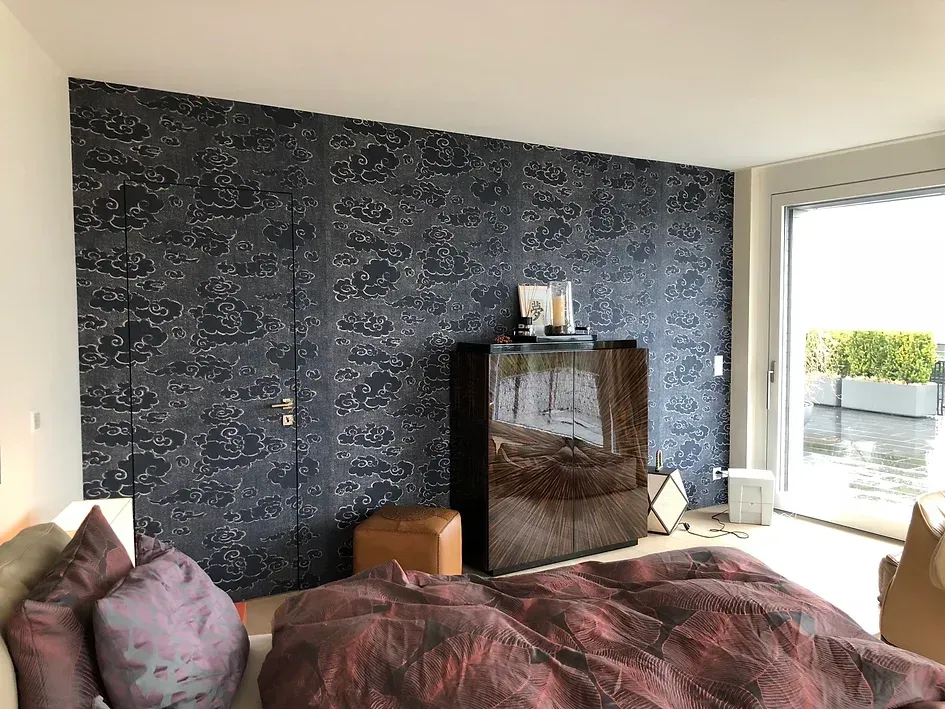 Ein Schlafzimmer mit Bett, Kommode, Fernseher und großem Fenster.