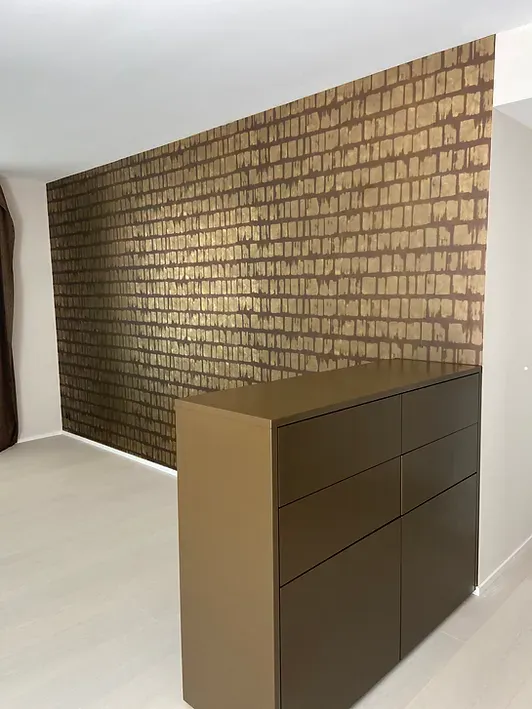 Ein Raum mit einer Ziegelwand und einer Kommode davor.