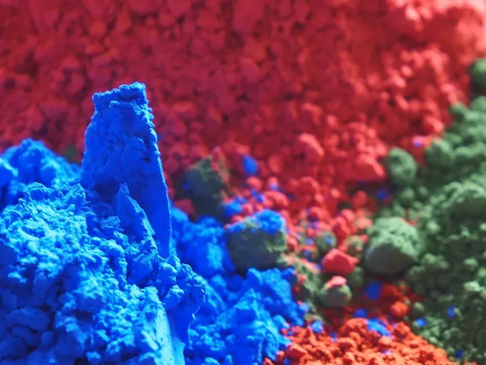 Ein Haufen verschiedenfarbiger Pulver, darunter Blau, Rot und Grün.