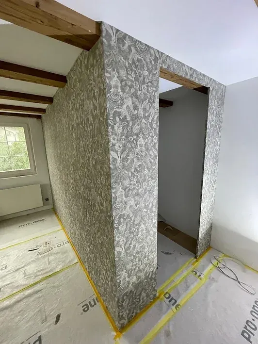 Ein Raum mit einer Wand zwischen zwei Räumen und einem Fenster.