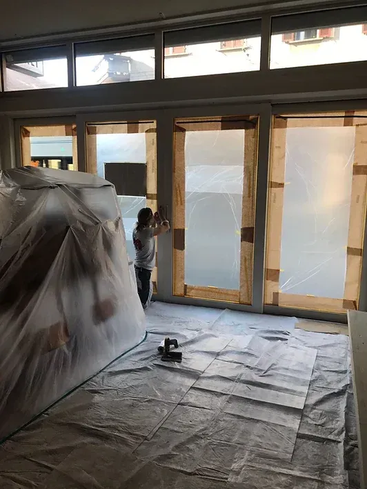 Eine Frau steht in einem mit Plastik bedeckten Raum.