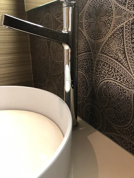 Ein Waschbecken mit Wasserhahn und Spiegel.