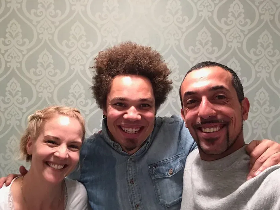 Drei Personen posieren für ein Foto und lächeln in die Kamera.