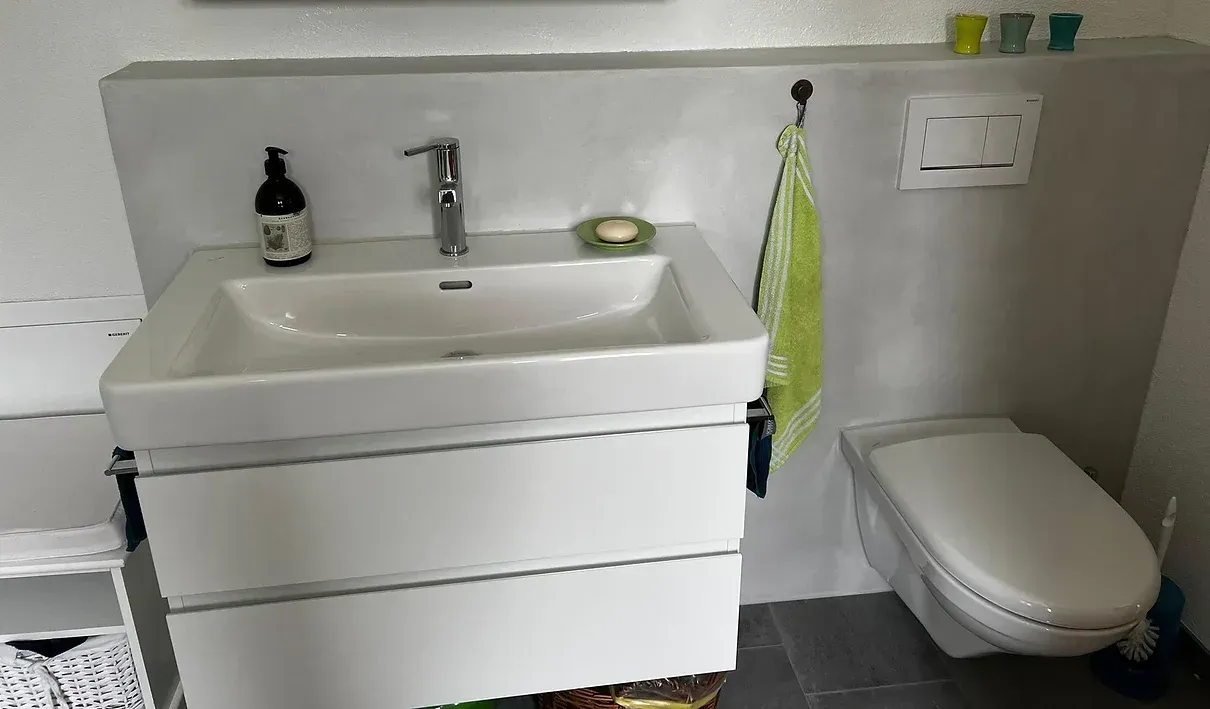 Ein Badezimmer mit Toilette, Waschbecken und Spiegel