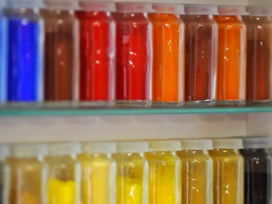 Ein Regal voller Flaschen mit verschiedenfarbigen Flüssigkeiten.