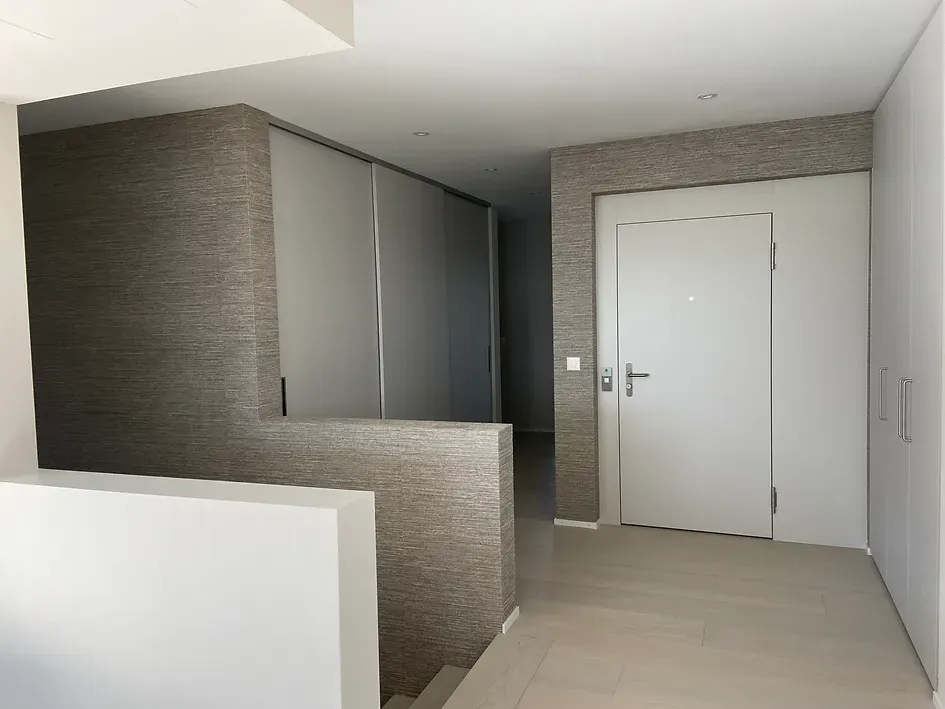 Ein leerer Flur mit einer weißen Tür und Treppe