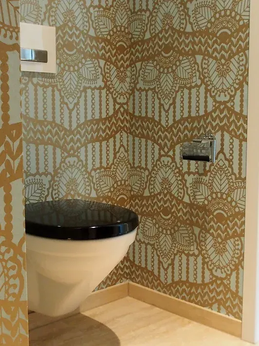 Eine Toilette in einem Badezimmer mit gemusterter Tapete