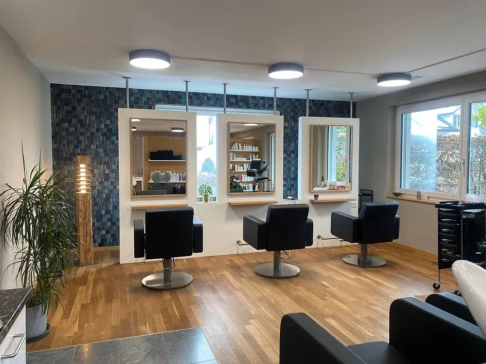 Ein Friseursalon mit zwei Stühlen und zwei Spiegeln.