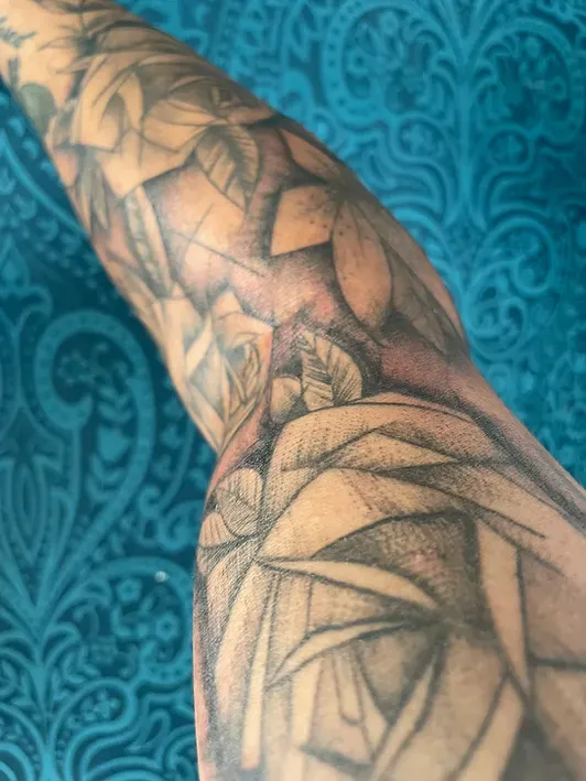 Eine Nahaufnahme des Arms einer Person mit einer Tätowierung darauf.