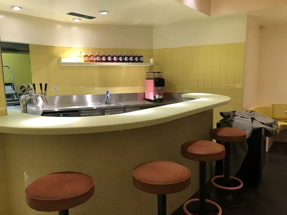 Eine Bar mit Hockern und einem Waschbecken in einem Raum