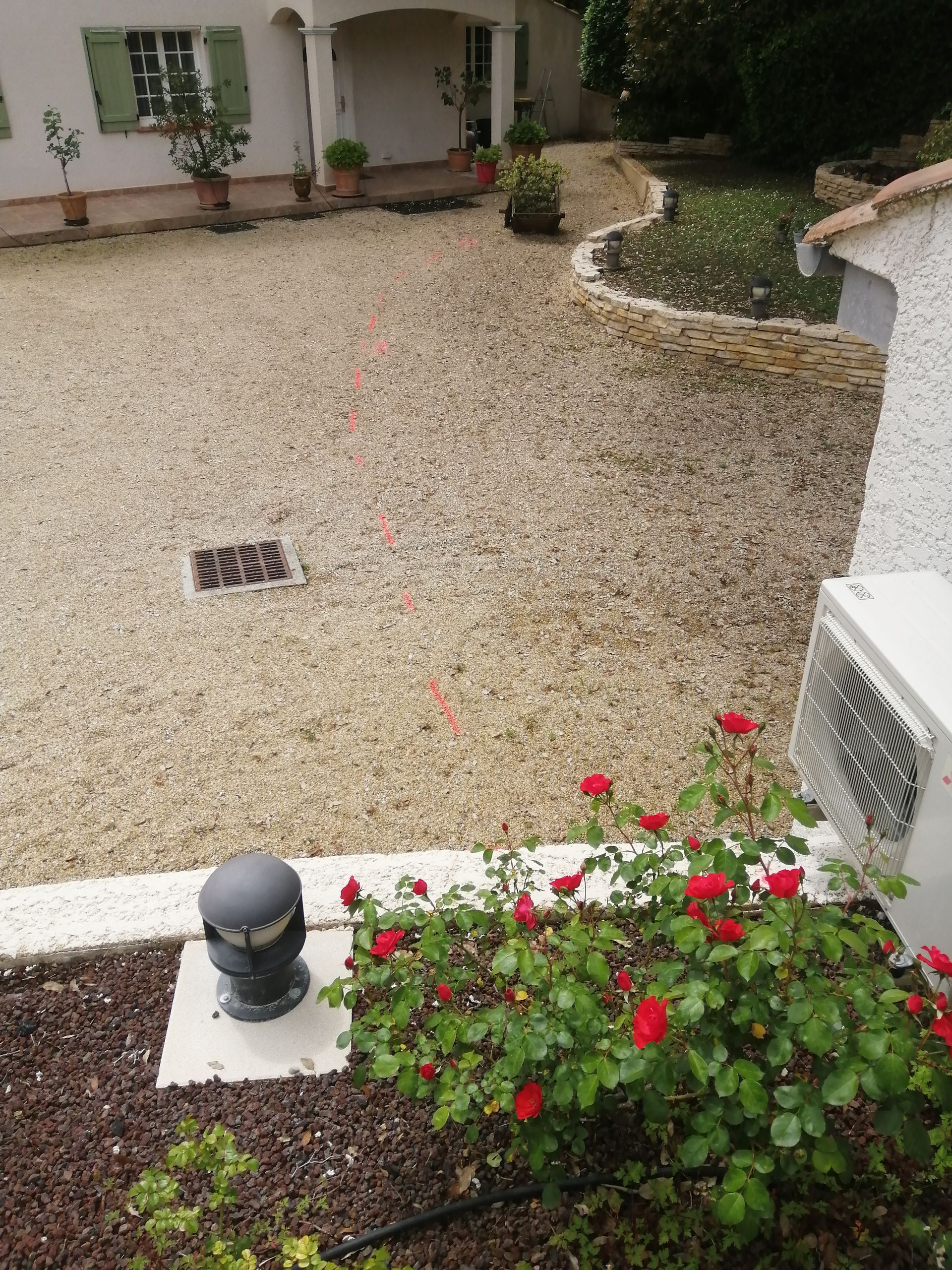 Traçage de la canalisation dans une cour en gravier