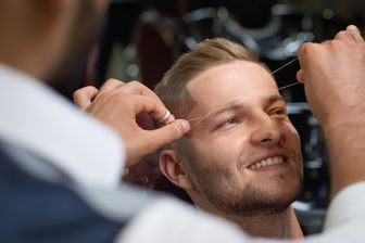 Coiffeur behandelt Augenbrauen