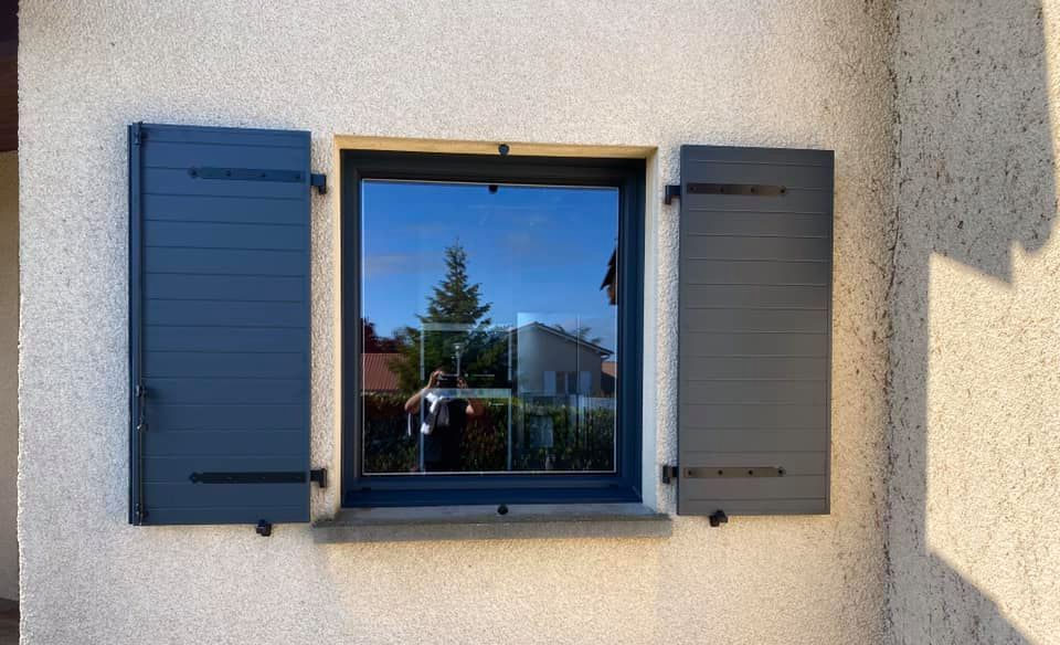 Une fenêtre et ses volets de couleur noir anthracite.