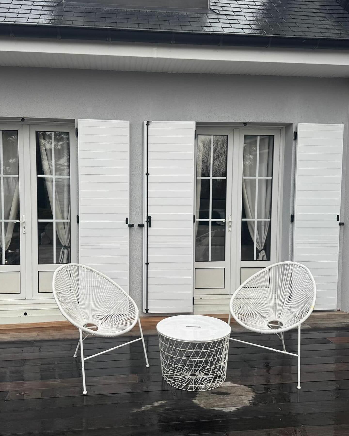 Volets blancs pour des portes-fenêtres à deux battants.