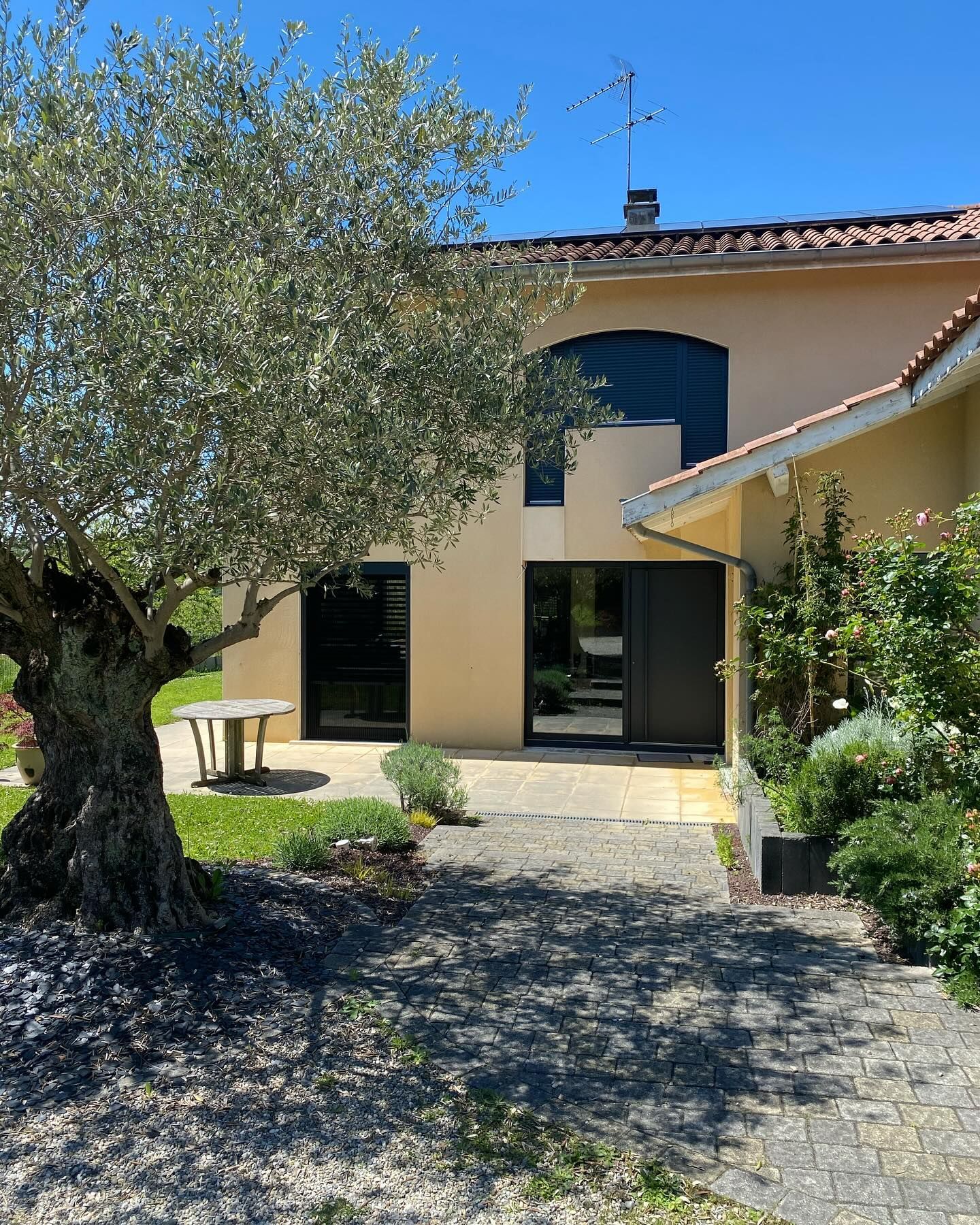 Extérieur d'une maison devant une allée de jardin.