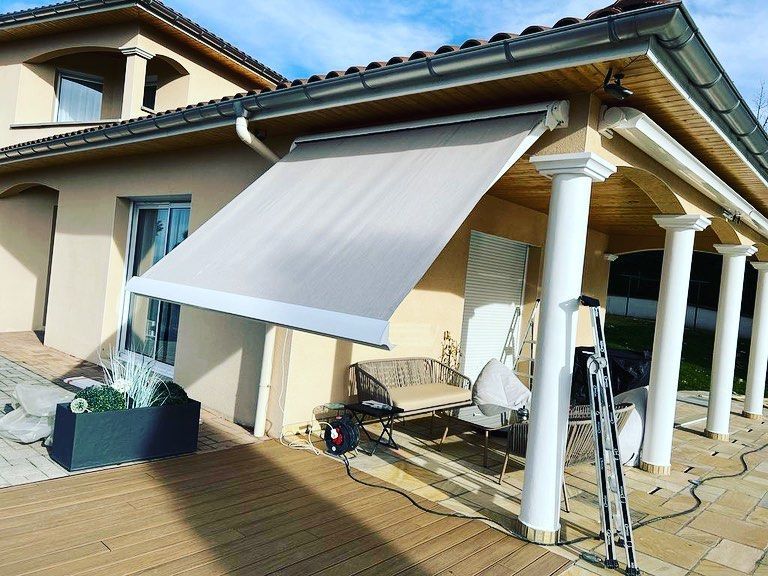 Un store dont la banne est déployée sur le côté d'une maison.