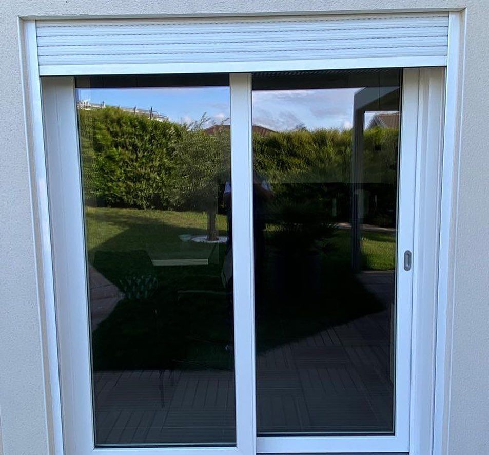 Volets roulants légèrement descendus sur une porte-fenêtre.