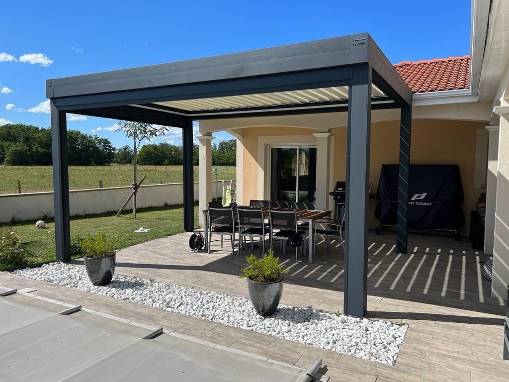 Terrasse avec table et chaises sous une pergola.
