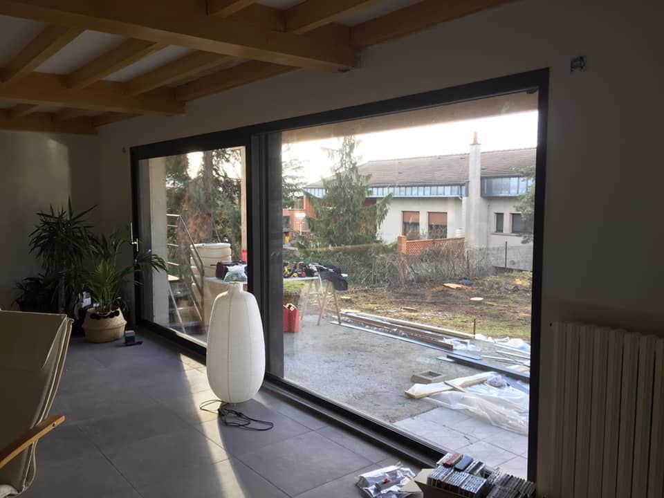 Baie vitrée coulissante fermée donnant sur un jardin.