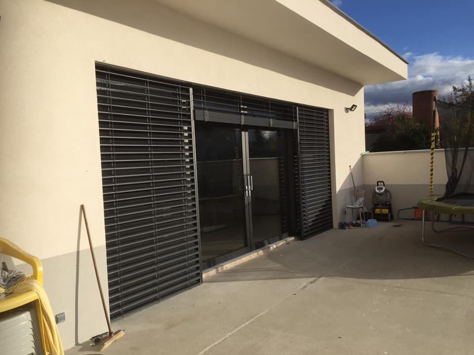 Deux volets roulants extérieurs abaissés sur les grandes baies vitrées.