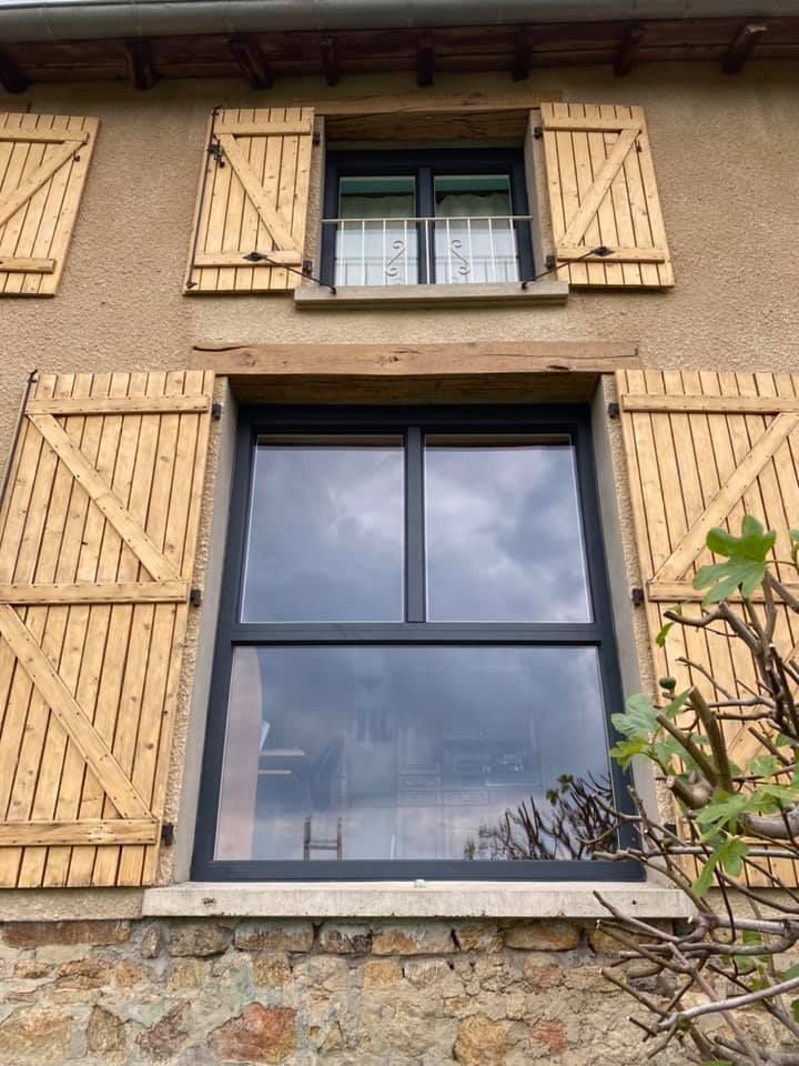 Des volets en bois clair pour une fenêtre.