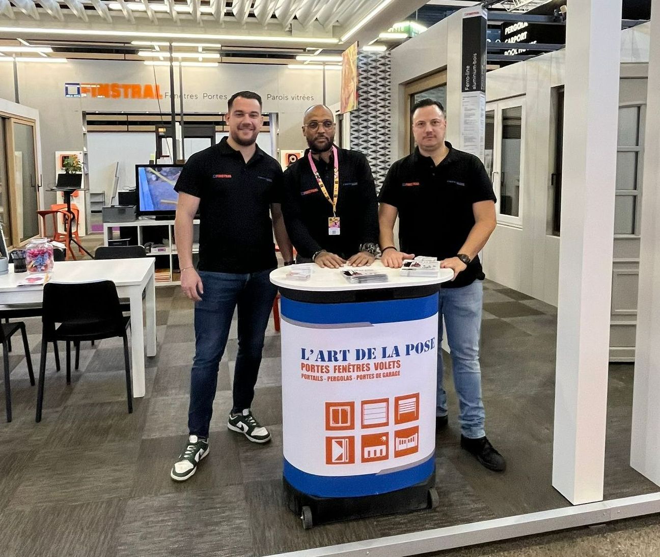 Trois personnes posant devant le stand de L'Art de la pose.