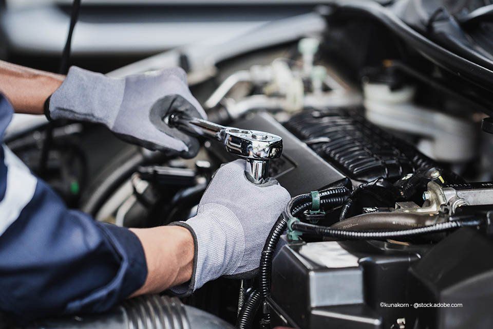 Mitarbeiter der Will Beyer GmbH repariert den Motor eines Autos