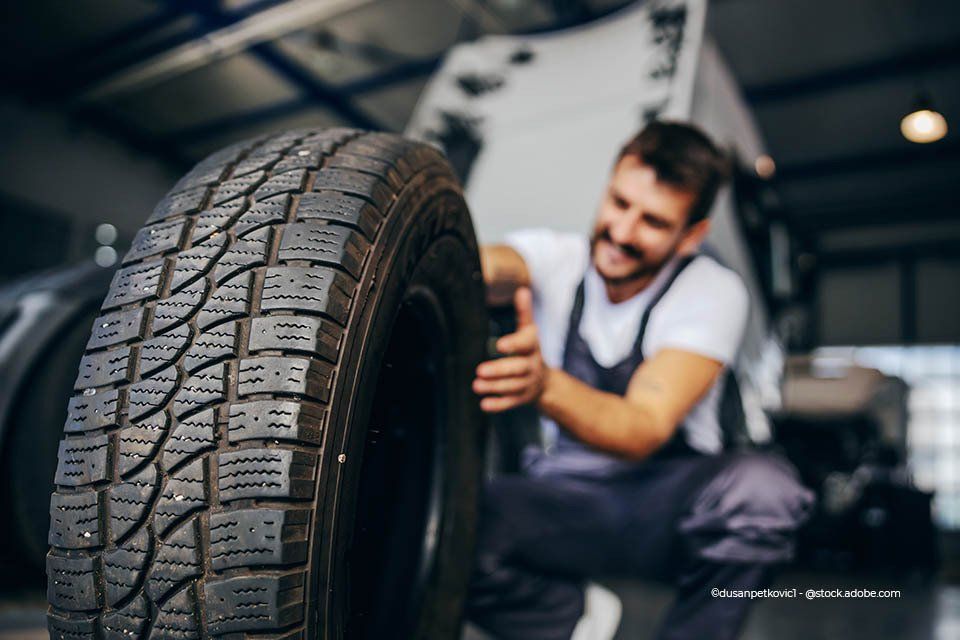 Mitarbeiter der Willi Beyer GmbH wechselt den Reifen eines Autos