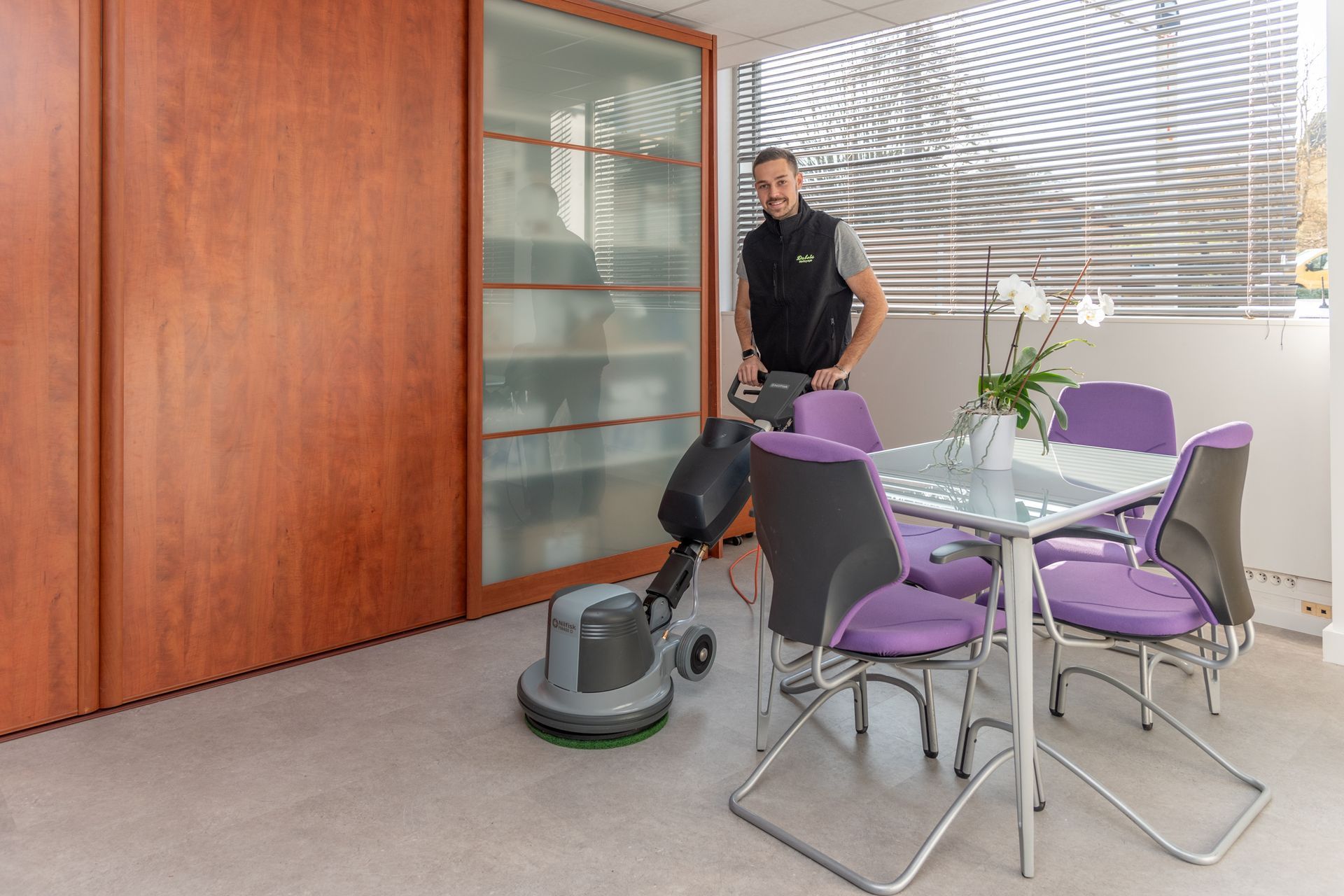 Une personne passe la shampouineuse dans un bureau