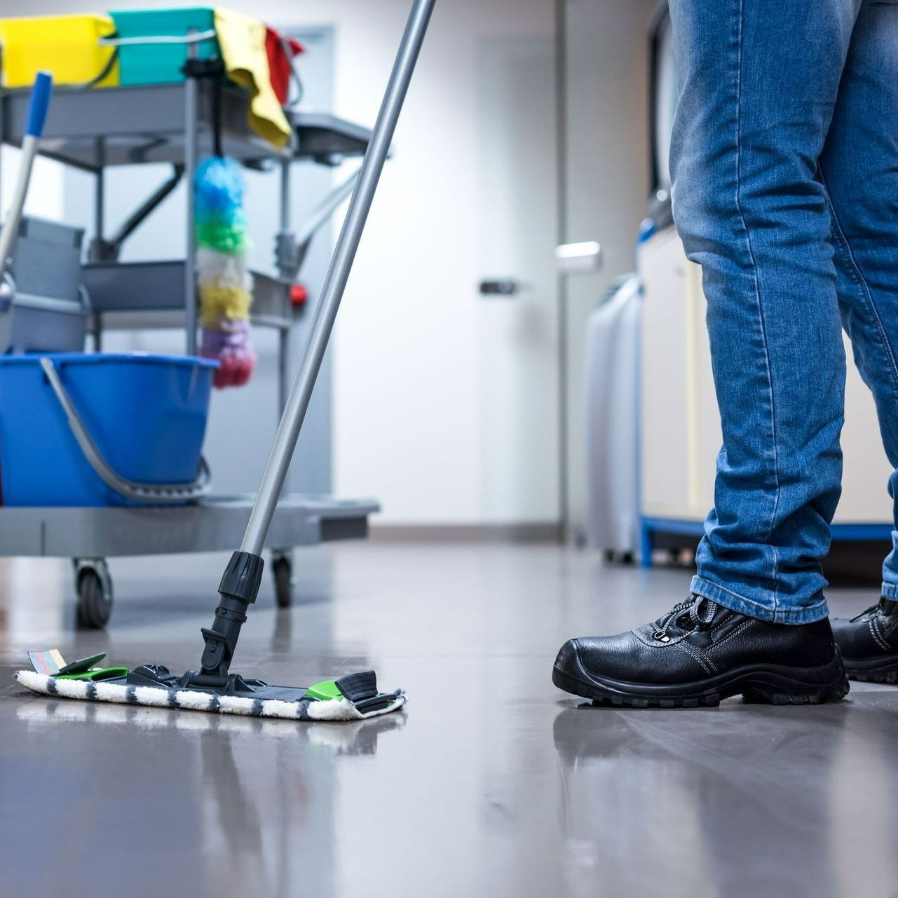 Plan serré sur les jambes d'un professionnel en train de passer le balai de lavage à plat.