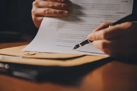 Una persona está firmando un documento con una pluma fuente.